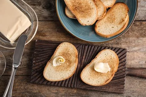 Flat lay composition with bread and butter on wooden table Stock Photos