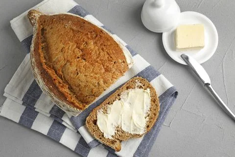 Flat lay composition with bread and butter on grey table Stock Photos