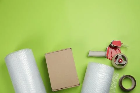 Flat lay composition with bubble wrap rolls on green background, space for te Stock Photos