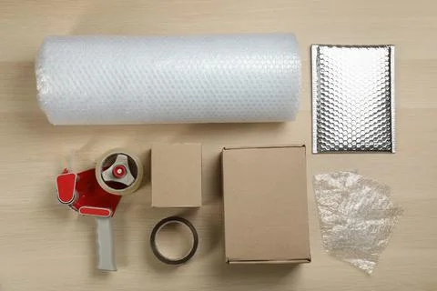 Flat lay composition with bubble wrap roll on wooden background Stock Photos