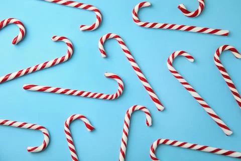 Flat lay composition with candy canes on light blue background Stock Photos