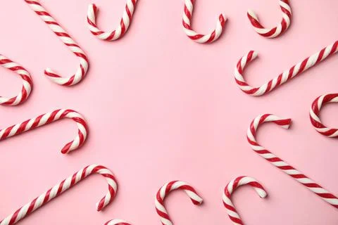 Flat lay composition with candy canes on pink background. Space for text Stock Photos
