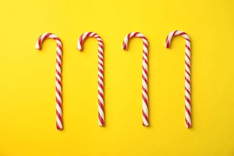Flat lay composition with candy canes on yellow background Stock Photos