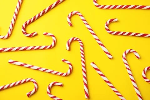 Flat lay composition with candy canes on yellow background Stock Photos
