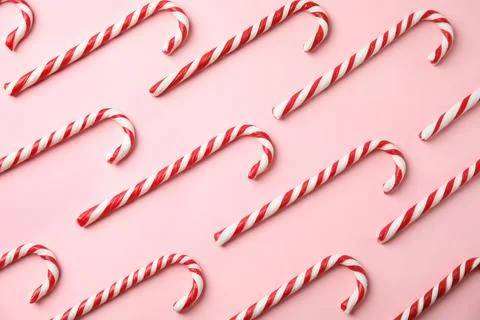 Flat lay composition with candy canes on pink background Stock Photos
