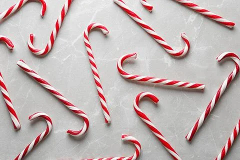 Flat lay composition with candy canes on grey marble background. Traditional  Stock Photos