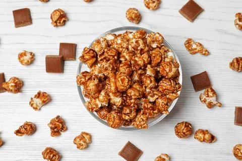 Flat lay composition with caramel popcorn on white wooden background Stock Photos
