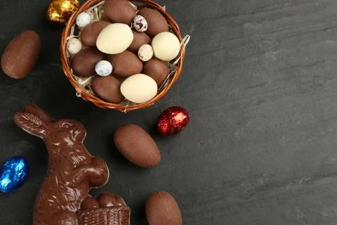 Flat lay composition with chocolate Easter bunny and eggs on black table. Spa Stock Photos