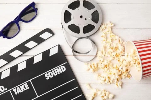 Flat lay composition with clapper, popcorn and 3D glasses on wooden backgroun Stock Photos