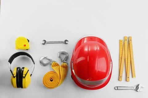 Flat lay composition with construction tools and safety equipment on white ba Stock Photos