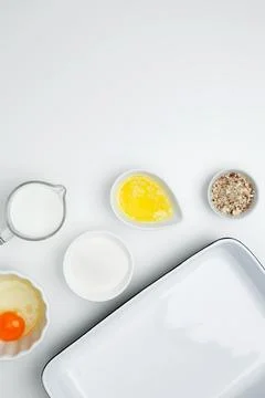 Flat lay composition for cooking preparation. Empty white baking dish with in Stock Photos