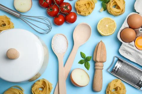 Flat lay composition with cooking utensils and fresh ingredients on light blu Stock Photos