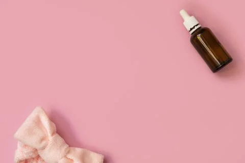 Flat lay composition with cosmetic bottle of serum or oil and facial headband on 库存照片