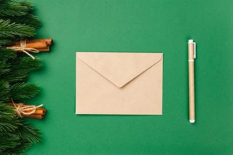 Flat lay composition of craft paper envelope and craft paper pen on green Stock Photos