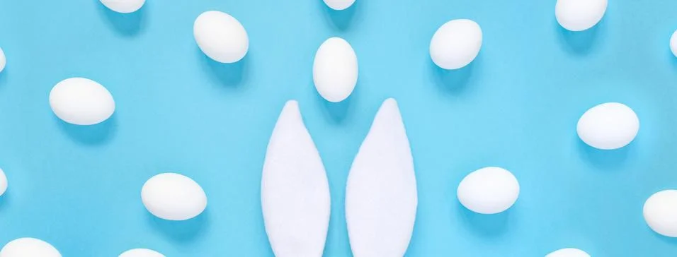 Flat lay composition of creative Easter bunny ears on blue background, space  Stock Photos