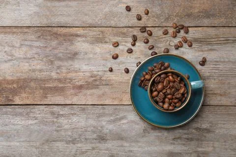 Flat lay composition with cup and coffee beans on wooden background Stock Photos