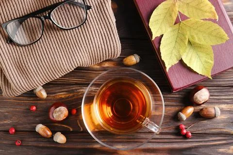Flat lay composition with cup of aromatic tea and soft sweater on wooden ta.. Stock Photos