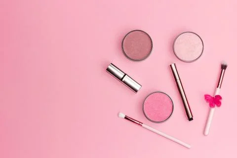 Flat lay composition with decorative makeup products on pastel pink background. Stock Photos