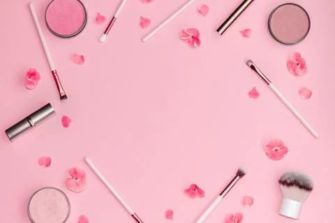 Flat lay composition with decorative makeup products and pink flowers on pastel Stock Photos