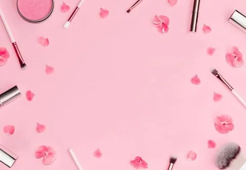 Flat lay composition with decorative makeup products and pink flowers on pastel Stock Photos