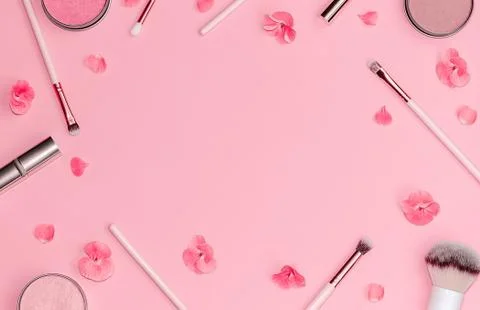 Flat lay composition with decorative makeup products and pink flowers on pastel Stock Photos