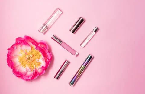 Flat lay composition with decorative makeup products, perfume and peony on pink Stock Photos