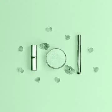 Flat lay composition with decorative makeup products and flowers on trendy mint Stock Photos