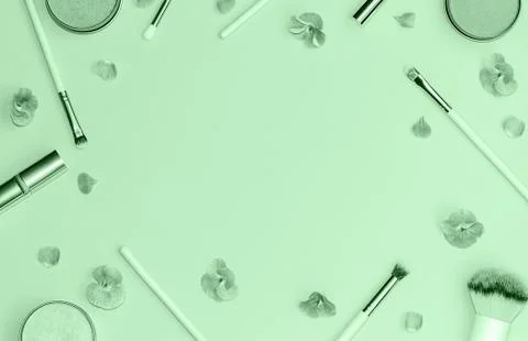 Flat lay composition with decorative makeup products and flowers on trendy mint Stock Photos
