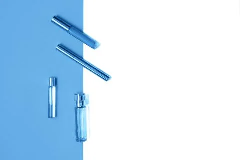 Flat lay composition with decorative makeup products and parfume on trendy blue Stock Photos