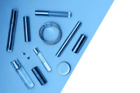 Flat lay composition with decorative makeup products and parfume on trendy blue Foto stock