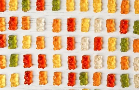 Flat lay composition with delicious color jelly bears on wooden table Foto stock