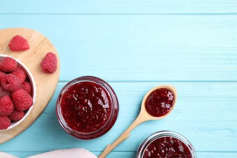 Flat lay composition with delicious raspberry jam on light blue wooden table. Foto stock