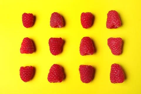 Flat lay composition with delicious ripe raspberries on yellow background Foto stock