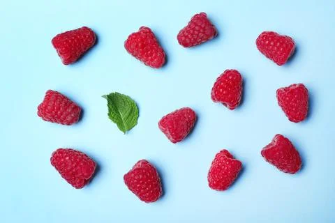 Flat lay composition with delicious ripe raspberries on blue background Foto stock