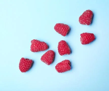 Flat lay composition with delicious ripe raspberries on blue background Foto stock