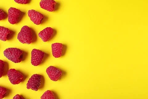 Flat lay composition with delicious ripe raspberries on yellow background. Sp Foto stock