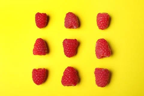 Flat lay composition with delicious ripe raspberries on yellow background Foto stock