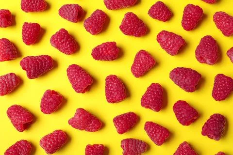 Flat lay composition with delicious ripe raspberries on yellow background Foto stock