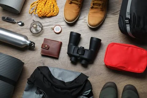 Flat lay composition with different camping equipment on wooden background Stock Photos