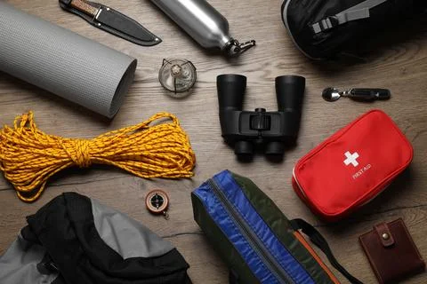 Flat lay composition with different camping equipment on wooden background Stock Photos