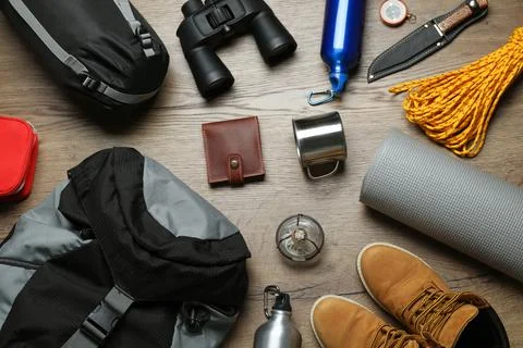 Flat lay composition with different camping equipment on wooden background Stock Photos