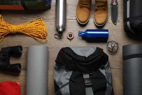 Flat lay composition with different camping equipment on wooden background Stock Photos