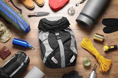 Flat lay composition with different camping equipment on wooden background Stock Photos
