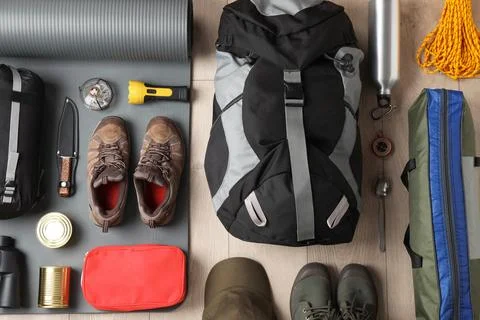 Flat lay composition with different camping equipment on wooden background Stock Photos