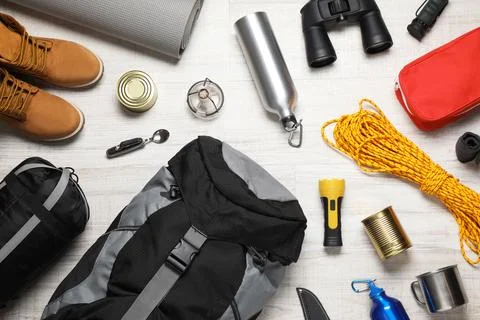 Flat lay composition with different camping equipment on wooden background Stock Photos