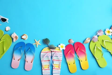 Flat lay composition with different flip flops on blue background, space for  Stock Photos