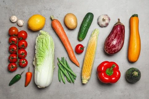 Flat lay composition of different fresh vegetables on grey table Foto stock