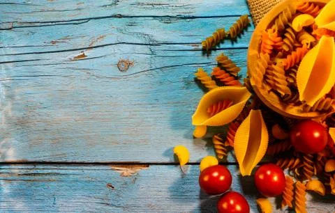 Flat lay composition with different pasta and tomatoes on color background Stock Photos