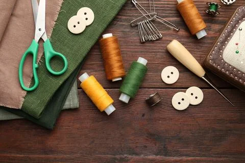 Flat lay composition with different sewing supplies on wooden table Stock Photos