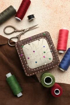 Flat lay composition with different sewing supplies on beige textured table Stock Photos